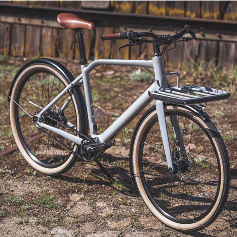 Das Fahrrad Schindelhauer Emil in Farbe mineralgrau ist in einem Hof abgestellt