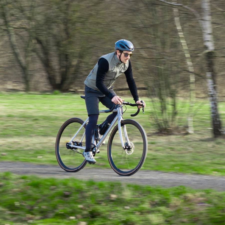 Ein Mann fährt mit Schindelhauer Wilhelm Gravel Alu Pur auf einen Feldweg