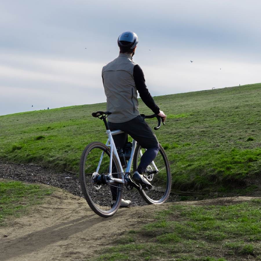 Ein Mann fährt mit Schindelhauer Wilhelm Gravel über einen Dünen Hügel