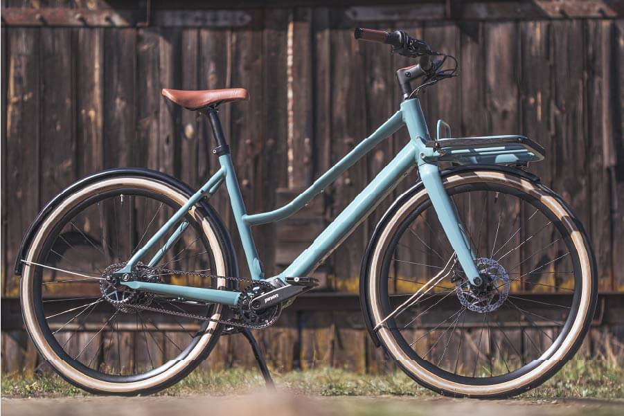 Ein Fahrrad Schindelhauer Emilia in Farbe salbeigrün steht im Park